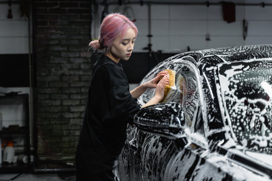 Car wash professional carefully drying a vehicle